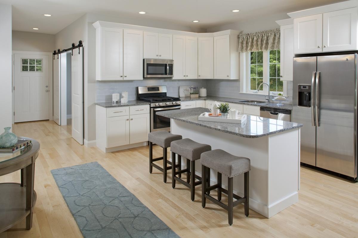 White shaker kitchen with granite island and stainless appliances