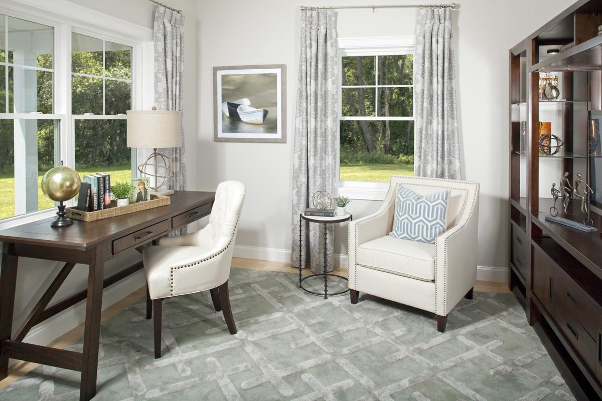 Study with desk and armchair overlooking the lawn